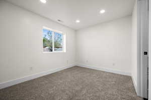 Empty room featuring carpet, recessed lighting, and baseboards