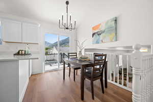 Dining room featuring a chandelier, wood finished floors, a mountain view, and baseboards