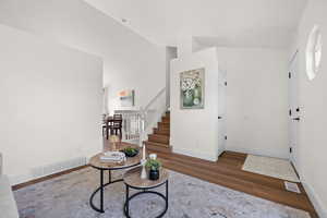 Entrance foyer featuring wood finished floors, stairway, and baseboards