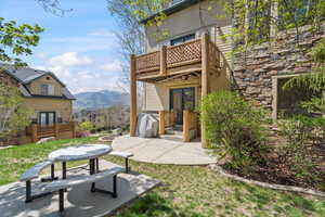 Exterior space with a mountain view, a patio area, french doors, and a balcony