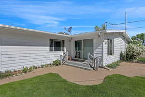 Rear view of house featuring a patio and a yard
