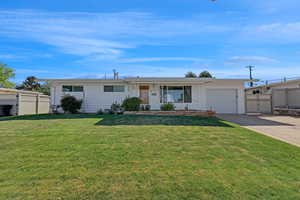 Ranch-style home with a garage, driveway, fully fenced in Vinyl.  with gate and storage behind