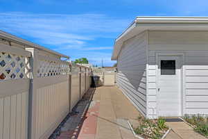 View of side of property with fence and a gate