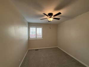 Carpeted spare room with a ceiling fan and a textured ceiling