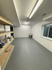 Finished basement featuring a textured ceiling