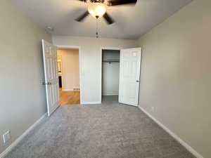 Unfurnished bedroom with light carpet, ceiling fan, and a closet