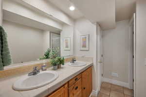 Full bath featuring double vanity, baseboards, tile patterned floors, and recessed lighting