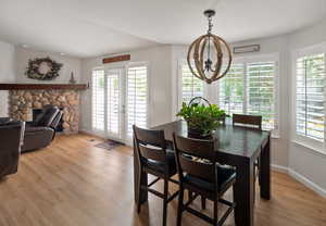 Dining area featuring a chandelier, plenty of natural light, light wood-type flooring, and baseboards