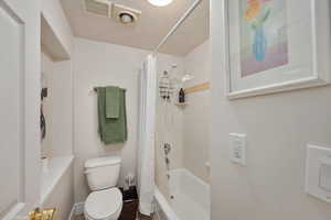 Full bath with toilet and shower / bathtub combination with curtain