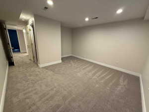 Finished below grade area with recessed lighting and light colored carpet