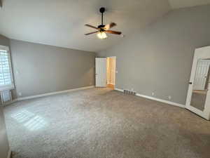 Unfurnished bedroom with carpet flooring, a ceiling fan, and high vaulted ceiling