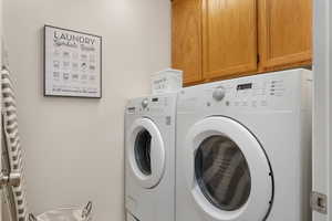 Laundry room featuring cabinet space and separate washer and dryer
