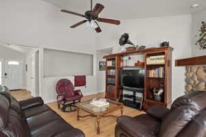 Living area featuring vaulted ceiling, a ceiling fan, wood finished floors, and baseboards