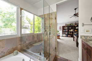 Full bathroom featuring plenty of natural light, vanity, a shower stall, and a ceiling fan