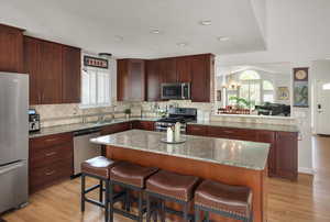 Kitchen with appliances with stainless steel finishes, tasteful backsplash, a chandelier, a sink, and recessed lighting