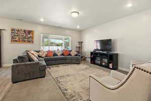 Living room featuring baseboards, wood finished floors, and recessed lighting