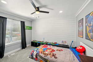 Bedroom with carpet, ornamental molding, wooden walls, a textured ceiling, and recessed lighting