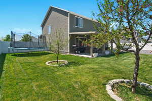 Back of property with a trampoline and a patio area