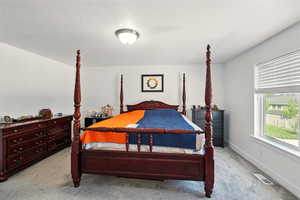Bedroom featuring light colored carpet and baseboards