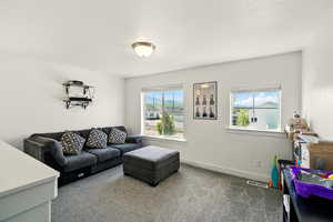 Carpeted living area featuring baseboards
