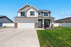 Craftsman house with driveway, an attached garage, board and batten siding, a porch, and stone siding