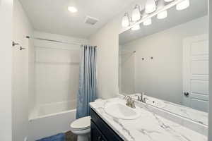 Full bath with toilet, shower / bath combo, and vanity