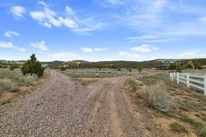 View of dirt / gravel driveway featuring a view of rural / pastoral area