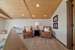 Living area with carpet, wooden ceiling, recessed lighting, and baseboards