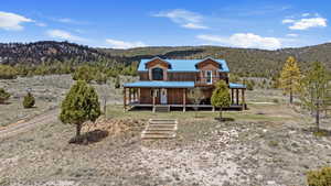 View of front of home featuring covered porch, a mountain view, metal roof, and a view of trees