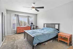 Bedroom with light carpet, baseboards, a ceiling fan, and a textured ceiling