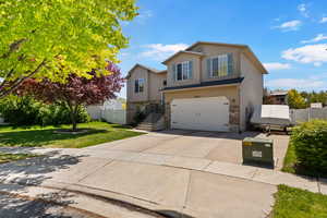 View of front facade featuring a garage, driveway, and stairway