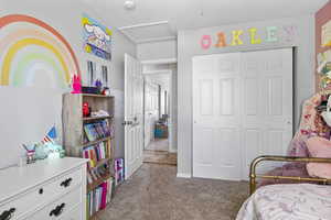 Bedroom with attic access, a closet, and carpet flooring