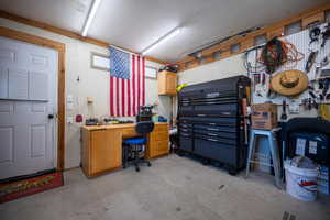Home office featuring concrete flooring and a workshop area
