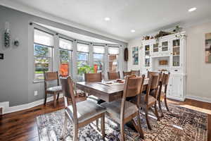 Dining area with ornamental molding, baseboards, wood finished floors, and recessed lighting