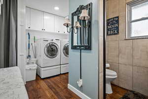 Washroom featuring washer and clothes dryer, dark wood-type flooring, and recessed lighting