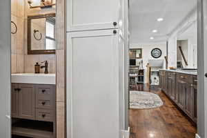 Bathroom with ornamental molding, vanity, wood finished floors, and recessed lighting