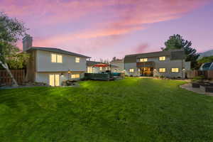 Rear view of property with a chimney and a wooden deck