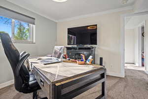 Carpeted office space with crown molding and baseboards