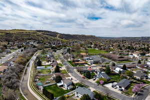 Aerial view of property and surrounding area featuring nearby suburban area and a mountainous background