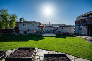 Rear view of house featuring a garden, a deck, and a chimney