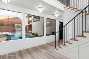 Stairs featuring wood finished floors and a chandelier