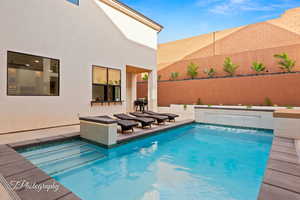 Outdoor pool with a fenced backyard and a patio