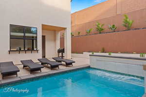 Outdoor pool featuring fence, a patio, and a grill