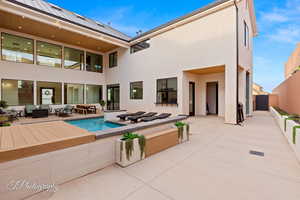 Rear view of house featuring outdoor lounge area, stucco siding, a patio, and a fenced backyard