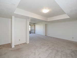 Living room featuring a textured ceiling, light colored carpet,.