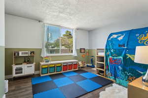 Playroom featuring wood finished floors and a textured ceiling