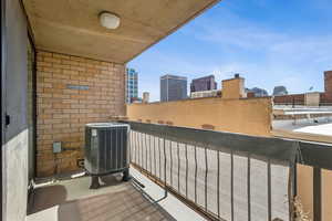 Balcony featuring cooling unit and a view of city