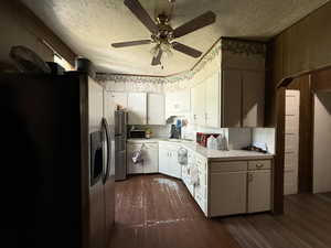 Kitchen featuring stainless steel fridge with ice dispenser, dark wood-style floors, light countertops, a textured ceiling, and a ceiling fan