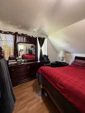 Bedroom featuring light wood-type flooring and lofted ceiling