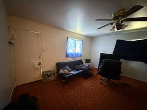 Carpeted office featuring a ceiling fan